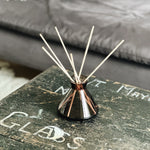 Elegant glass vase and diffuser bottle with reeds on coffee table