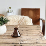 Minimalist smoky glass diffuser vessel on table