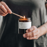 Person lighting a candle labeled 'hobo & co.'