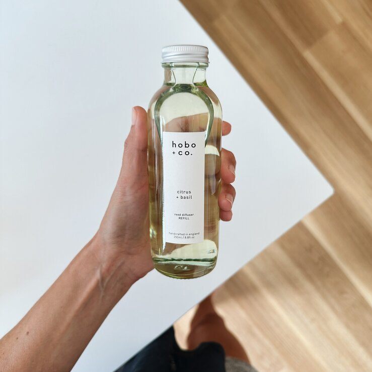clear glass reed diffuser bottle held in hand
