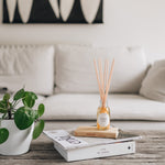 roam reed diffuser on a rustioc living room table with a cream sofa behind